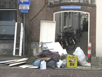 907695 Afbeelding van niet opgehaald grofvuil op de Lauwerecht te Utrecht, voor de ingang van de Schepenmakerssteeg.